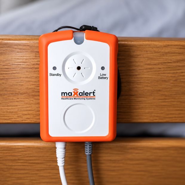 A Maxalert monitor unit mounted on a care bed rail